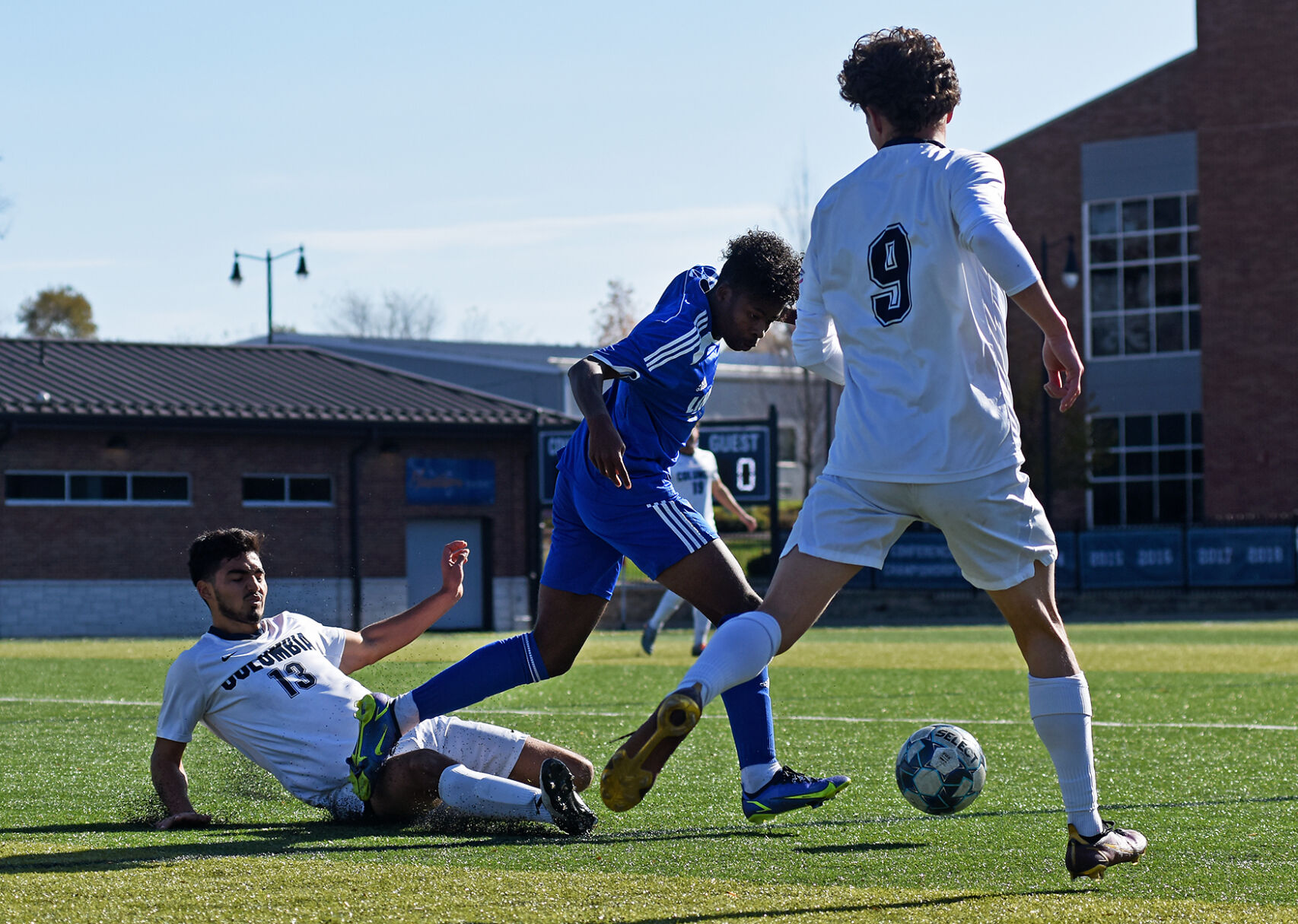 Diego Navia, left, and his teammate Gabriel Cisneros, right, try to stop Lindsey Wilson